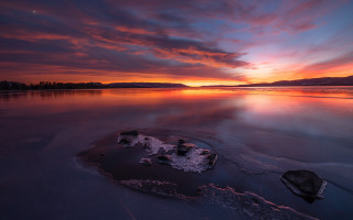 Sunset lake rock clouds cityscape - a rock in the middle of it free wallpaper