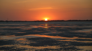 Sunset water boat clouds horizon 6 - a sunset over a body of water free wallpaper