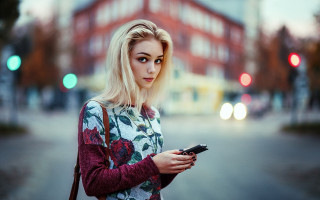 Woman street cellphone serious portrait - a street holding free wallpaper