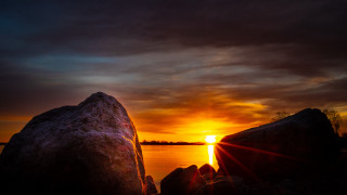 Sunset water rocks dark sky - a dark sky in the background free wallpaper