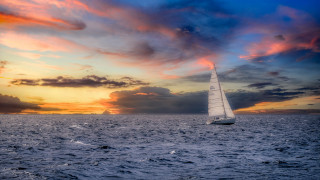 Sailboat ocean sunset cloudy sky 8 - a sun setting behind free wallpaper