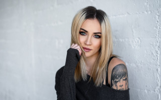 Woman tattoo portrait black blonde - a brick wall behind her free wallpaper