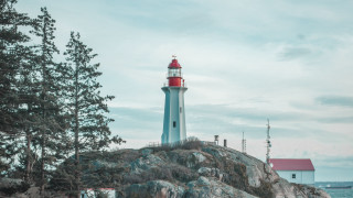 Lighthouse rocky outcropping red roof - a red roof free wallpaper