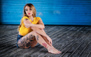 Tattooed woman sitting beach outdoors - leg free wallpaper