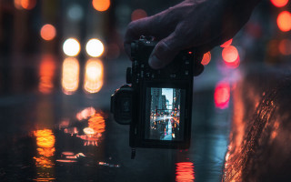 City lights night camera bokeh - a person holding free wallpaper