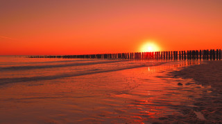 Sunset beach fence water orange - a sunset over a beach free wallpaper