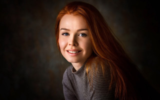 Woman red hair smiling dark - a black backdrop free wallpaper for desktop