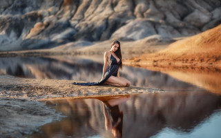 Woman rock water mountain beach - a mountain in the background and a body of water free wallpaper