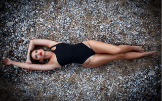 Woman black swimsuit rocky laying - a black swimsuit free wallpaper