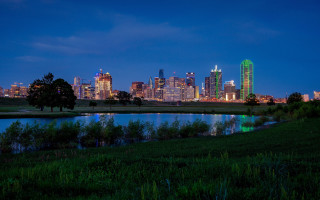 City skyline night lake grassy - a grassy field in the foreground free wallpaper