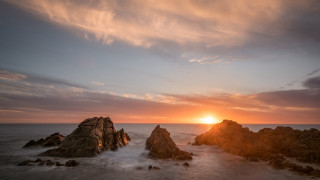 Sunset ocean rocks campfire city - the foreground and a body of water free wallpaper