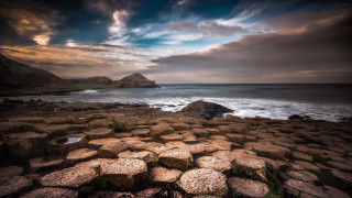 Rocky beach large body water - a rock formation in the foreground free wallpaper