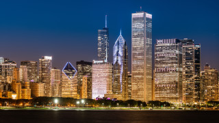 City skyline night skyscrapers reflections - the water and a boat in the foreground free wallpaper