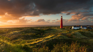Red lighthouse green field ocean - a lush green field next free wallpaper