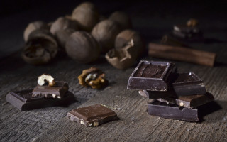 Chocolate nuts pile wooden table - product photography free wallpaper