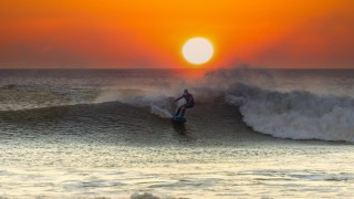 Surfer wave sunset ocean mountain - a surfboard in the ocean free wallpaper