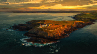 Lighthouse island ocean sunset clouds 2 - a small island in the middle of the ocean free wallpaper