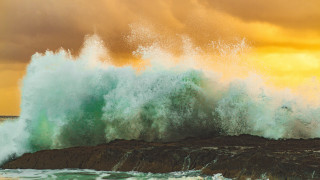 Stormy wave sunset shore surfer - a surfboard in the foreground free wallpaper