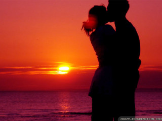 Couple kissing sunset beach silhouette 2 - the sun setting behind them free wallpaper for desktop