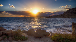 Sunset water rocks grass bridge - a sunset over a body of water free wallpaper