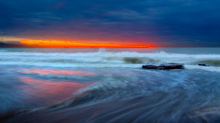 Sunset ocean waves boat red 2 - a boat in the distance free wallpaper