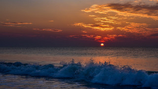 Sunset ocean wave surfboard city - a sunset over the ocean free wallpaper
