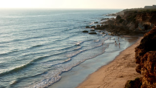 Beach cliff waves people sunset - a cliff and a body of water free wallpaper