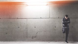 Man standing room cellphone light - dynamic lighting free wallpaper