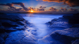 Sunset rocky beach water island - a long exposure of a sunset over a rocky beach free wallpaper