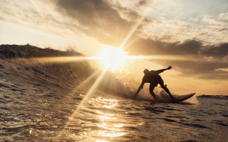 Surfing sunset ocean lens flare - a person riding free wallpaper