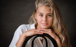 Blonde woman black purse portrait - a black background behind her free wallpaper