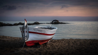 Beach sunset boat water mountain - a sunset in the background and a body of water free wallpaper