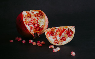 Pomegranate halved scattered food photography - a black surface free wallpaper for desktop