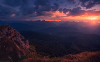 Sunset mountain range cityscape purple - a bright sun in the distance free wallpaper