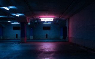 Dark parking garage neon sign - the wall above free wallpaper