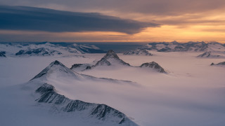 Snowy mountains cloudy sunset landscape - snow under a cloudy sky free wallpaper