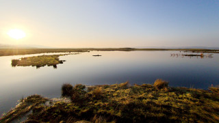 Lake boats sunset mountains sky - a sun in the background free wallpaper for desktop