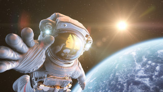 Space suit man waving planet - a bright sun in the sky free wallpaper