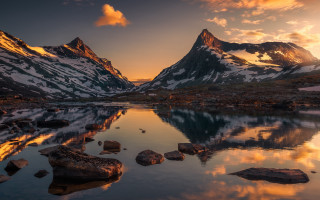 Mountain range lake rocks boulders - the foreground and a sunset in the background free wallpaper for desktop