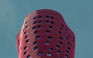Tall red building sky plane - free architecture wallpaper