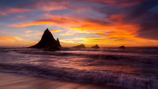 Sunset beach waves rock formation - a sunset over a beach free wallpaper