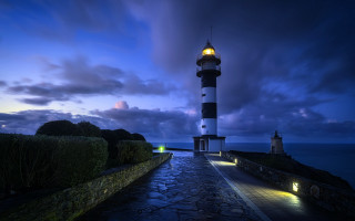 Lighthouse rocky shore night city - a rocky shore free wallpaper for desktop