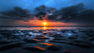 Sunset beach rocks water cloudy 3 - a sunset over a beach free wallpaper