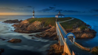 Lighthouse rocky cliff ocean night - a full moon in the sky above free wallpaper