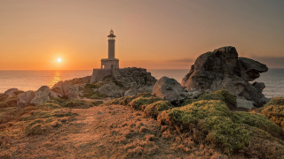 Lighthouse rockycliff sunset ocean beach - the background and the ocean in the foreground free wallpaper