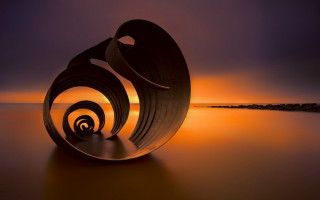 Sculpture water sunset spirals landart - a sunset in the background and a body of water free wallpaper