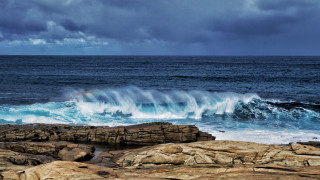 Wave crashing ocean cloudy rainbow - a rainbow in the sky above free wallpaper