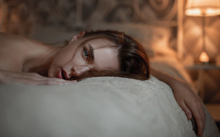 Woman laying on bed blue - the pillow free wallpaper