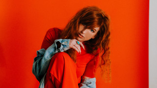 Red haired woman sitting backpack - studio portrait free wallpaper