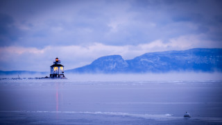 Lighthouse snowy beach mountains water - the background in the distance free wallpaper